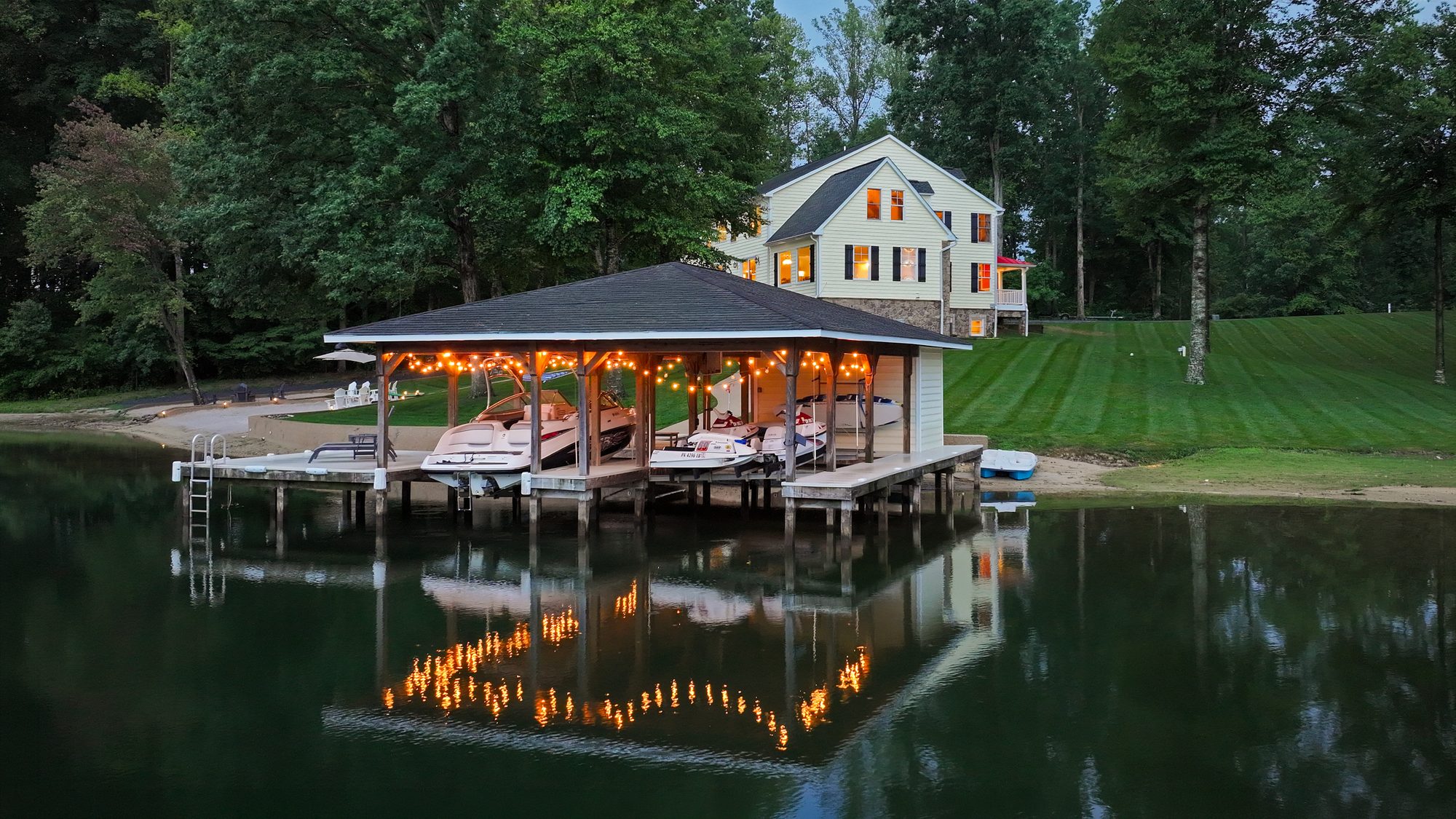 Twilight boathouse lit up on the water